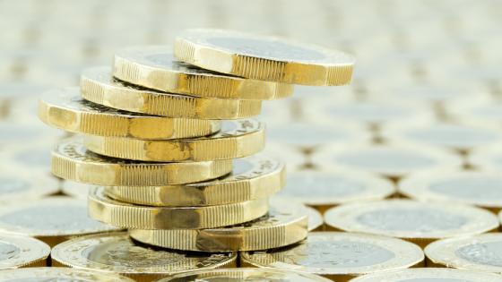 Precariously balanced stack of British one pound coins