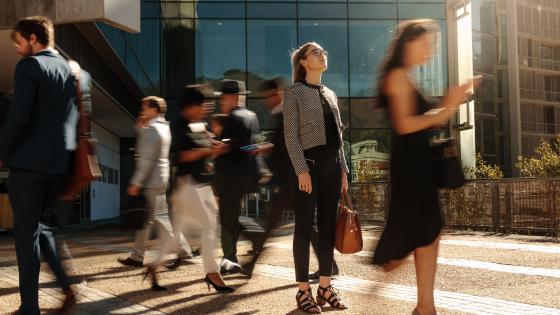 Businesswoman standing still on a busy street