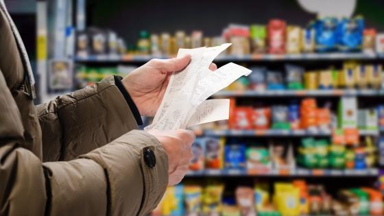 Man looking at receipt in supermarket