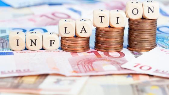 Inflation written on dice on top of stacks of euro coins