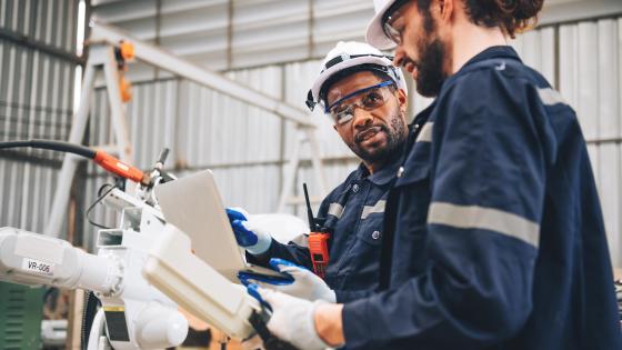 Engineers working on a robot in warehouse