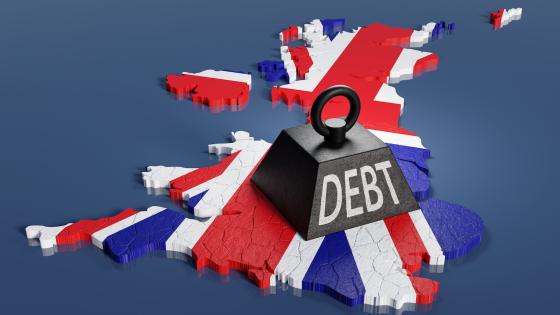 Black one ton weight marked with the word DEBT dropped on the national map of the UK